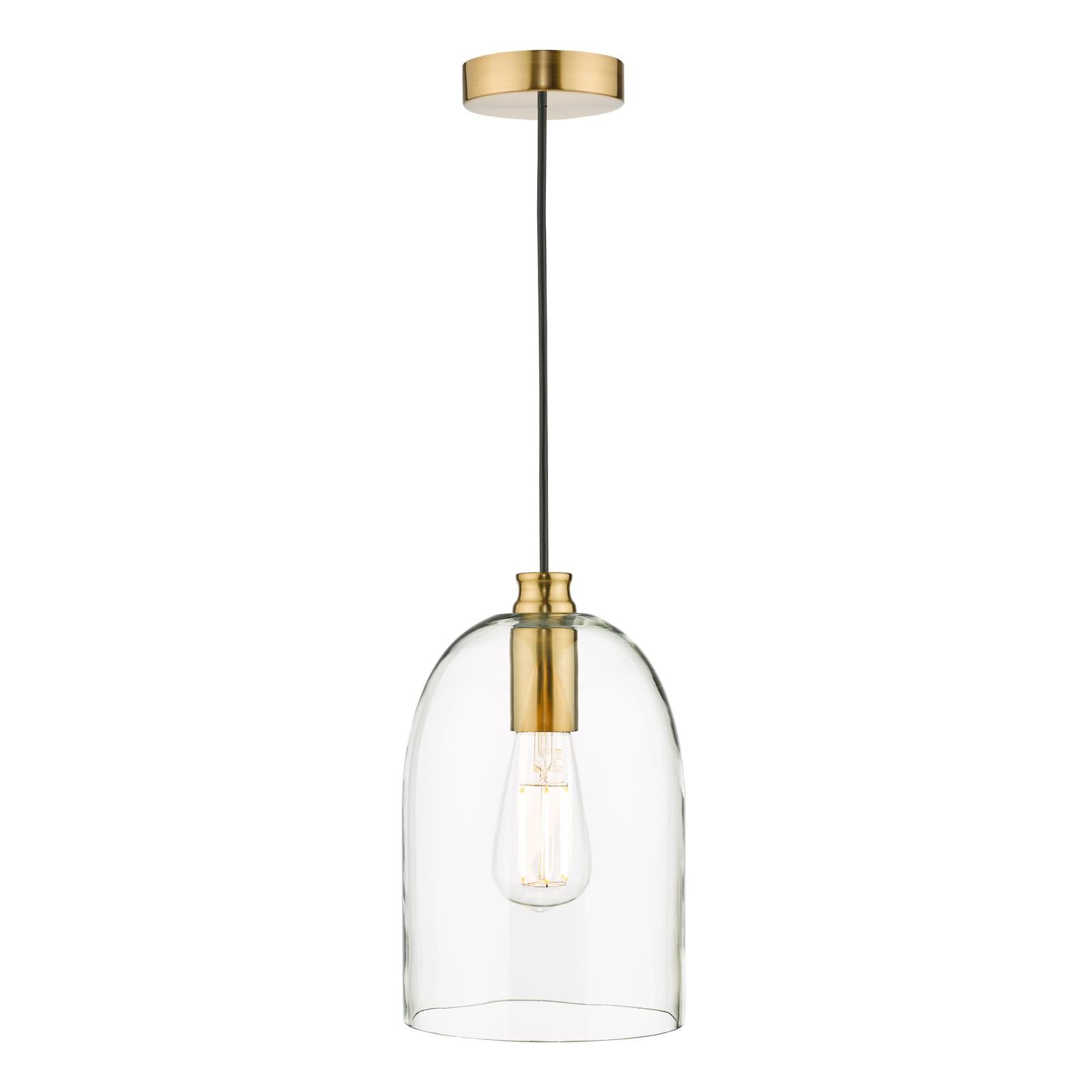 Clear glass pendant light above table with warm bulb